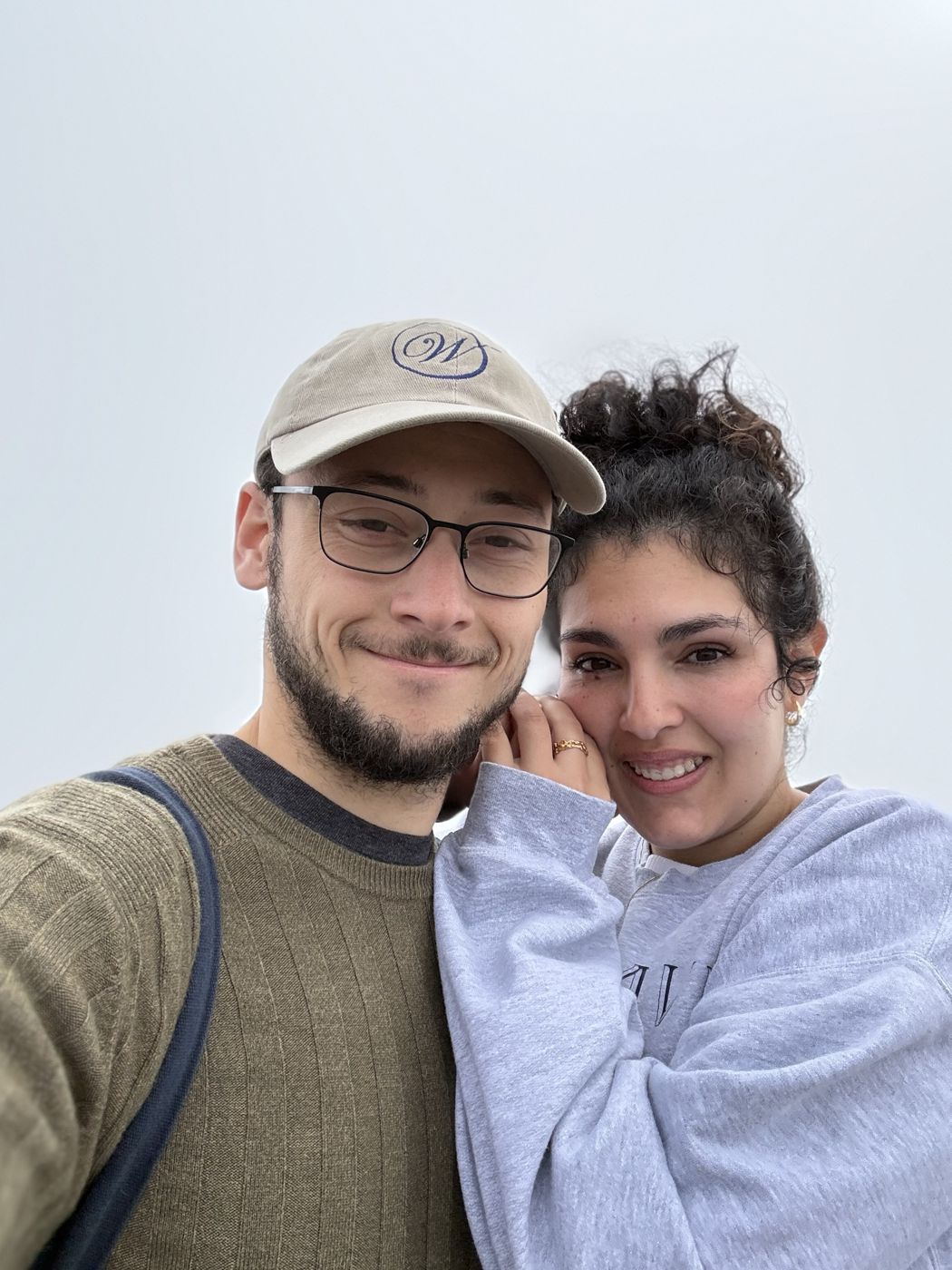 Tristan and Ileana smiling on a cloudy day