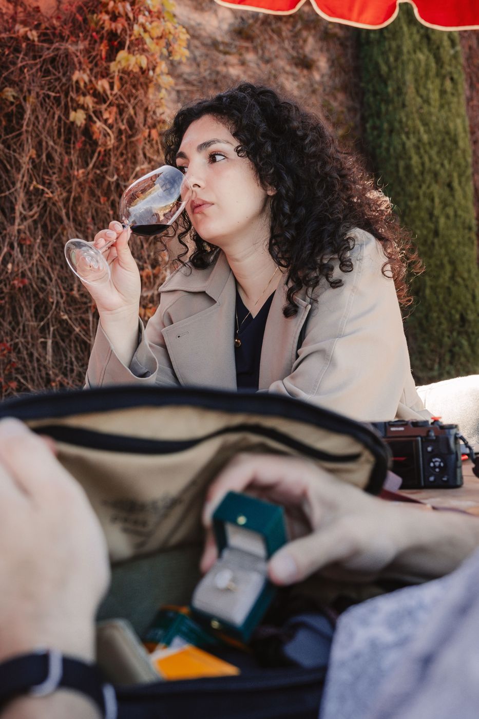 Ileana sipping wine while a ring box is pulled from a bag