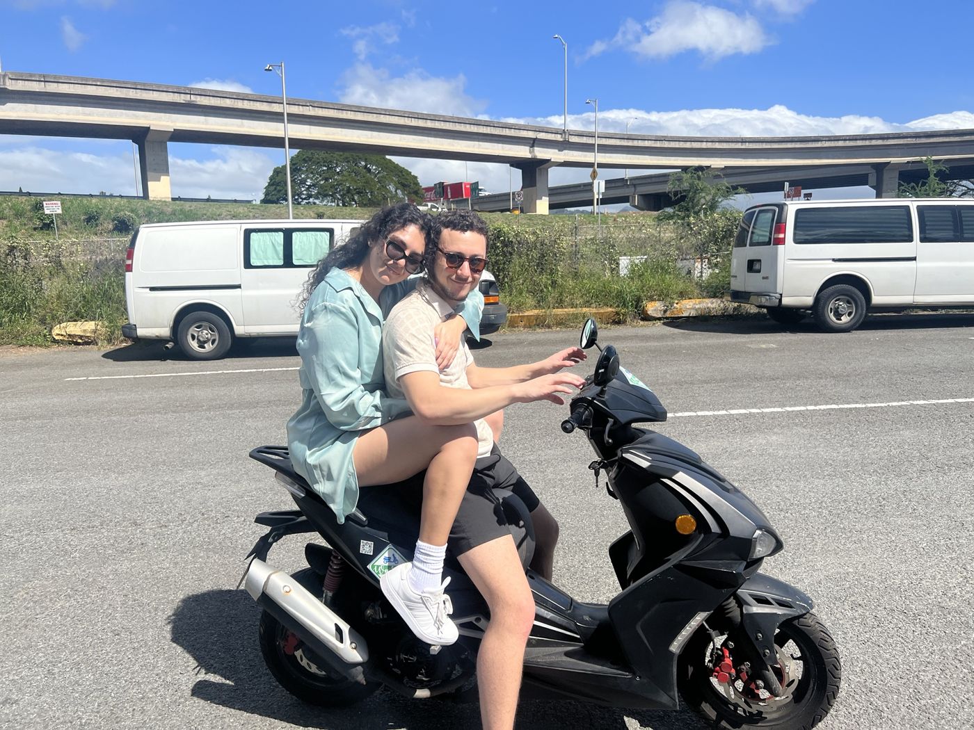 Ileana and Tristan riding a scooter in Hawaii